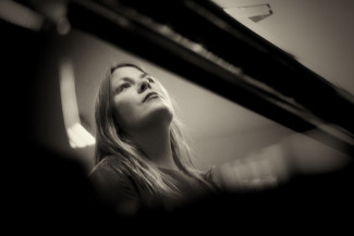 Ein schwarz-Weiß-Bild der Organistin Ann-Helena Schlüter. Sie sitzt an der Orgel, das Bild ist von unten aufggenomme, zu sehen ist ihr Kopf.